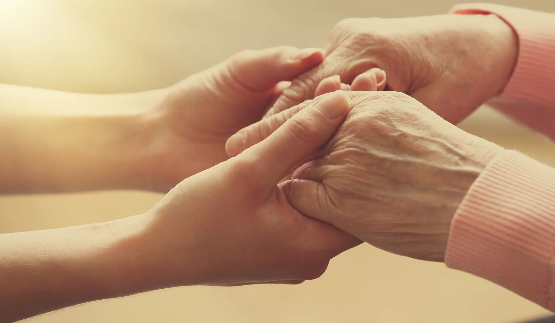 Photo représentant les mains d’une accompagnante qui tient les mains d’une personne malade