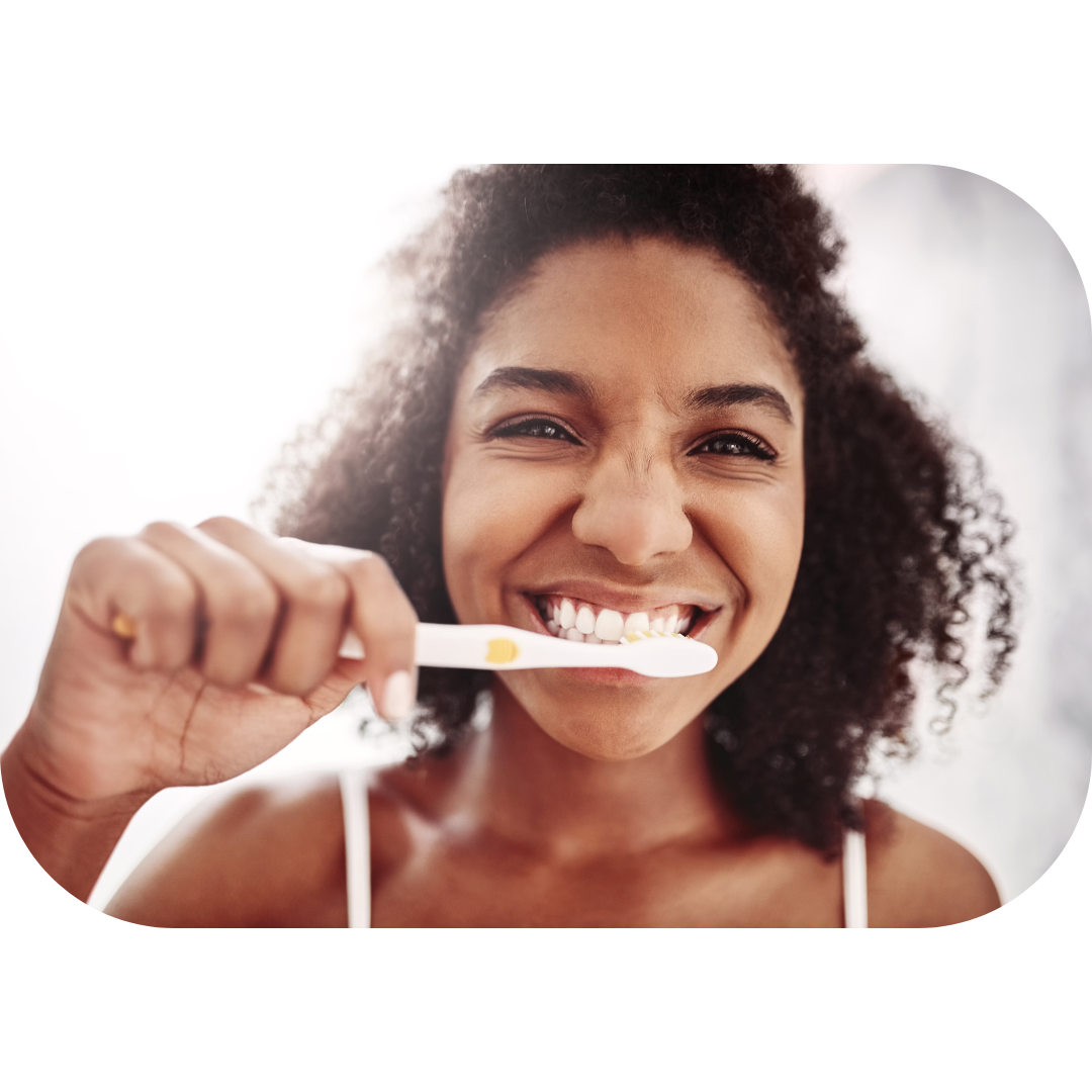 Photo représentant une femme qui se brosse les dents avec le sourire et en pleine conscience