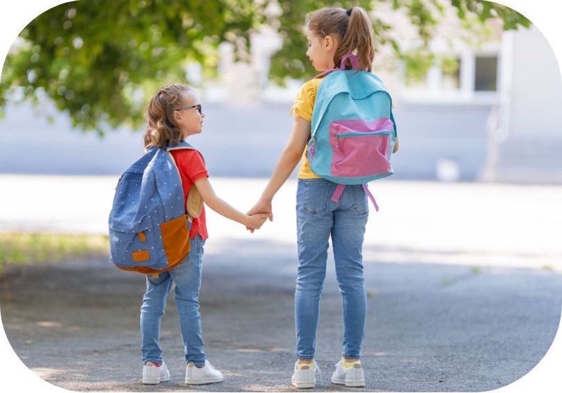 Photo représentant deux soeurs avec leur cartable sur le chemin de l'école