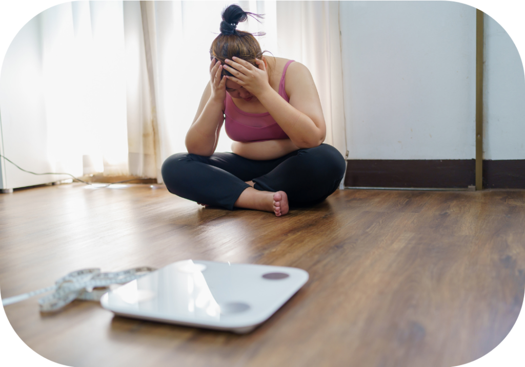 Femme en surpoids qui est malheureuse et semble pleurer devant sa balance